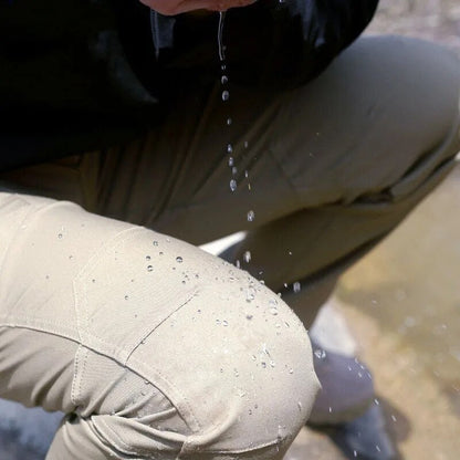 Close-up of a khaki trouser knee panel with water droplets beading on the fabric as water pours from above. 7