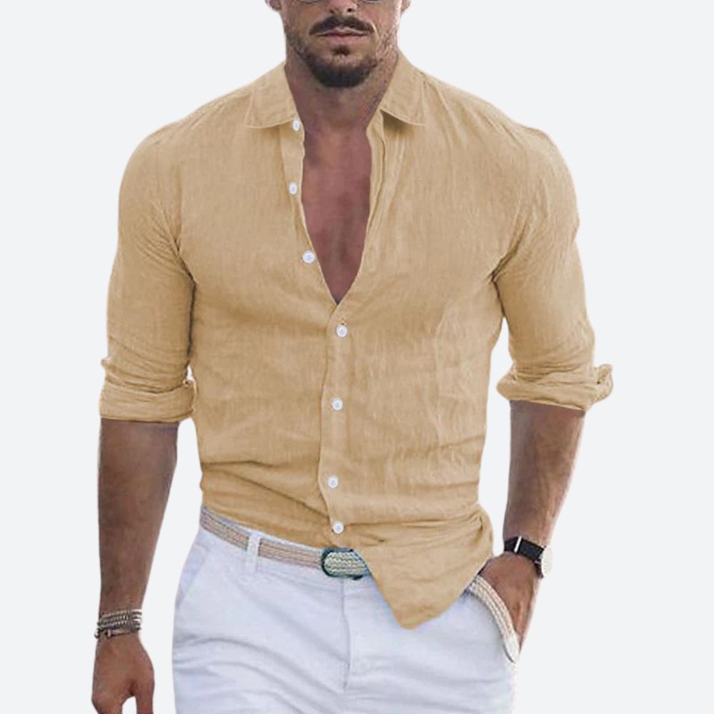 Man wearing the shirt in sandy beige, open at the collar with sleeves rolled, styled with white trousers and a woven belt. 8