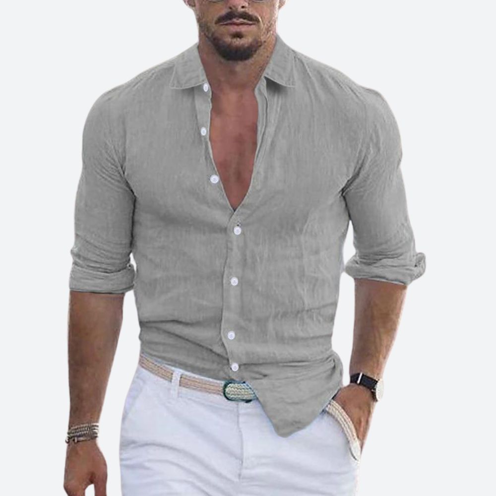 Man wearing the shirt in light grey, open at the collar with sleeves rolled, styled with white trousers and a woven belt. 6