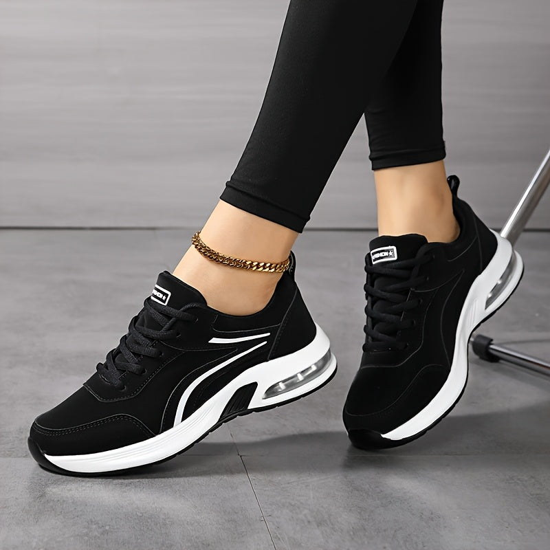 Model seated with ankles crossed, wearing black lace-up trainers with white stripes and air-cushion heels 5