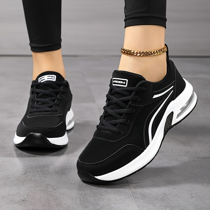 Front three-quarter view of black trainers with white side stripes, worn with black leggings and a gold anklet 2
