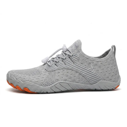 Side view of a light grey knit barefoot trainer with toggle laces, grey sole and orange toe tips on the outsole. 10