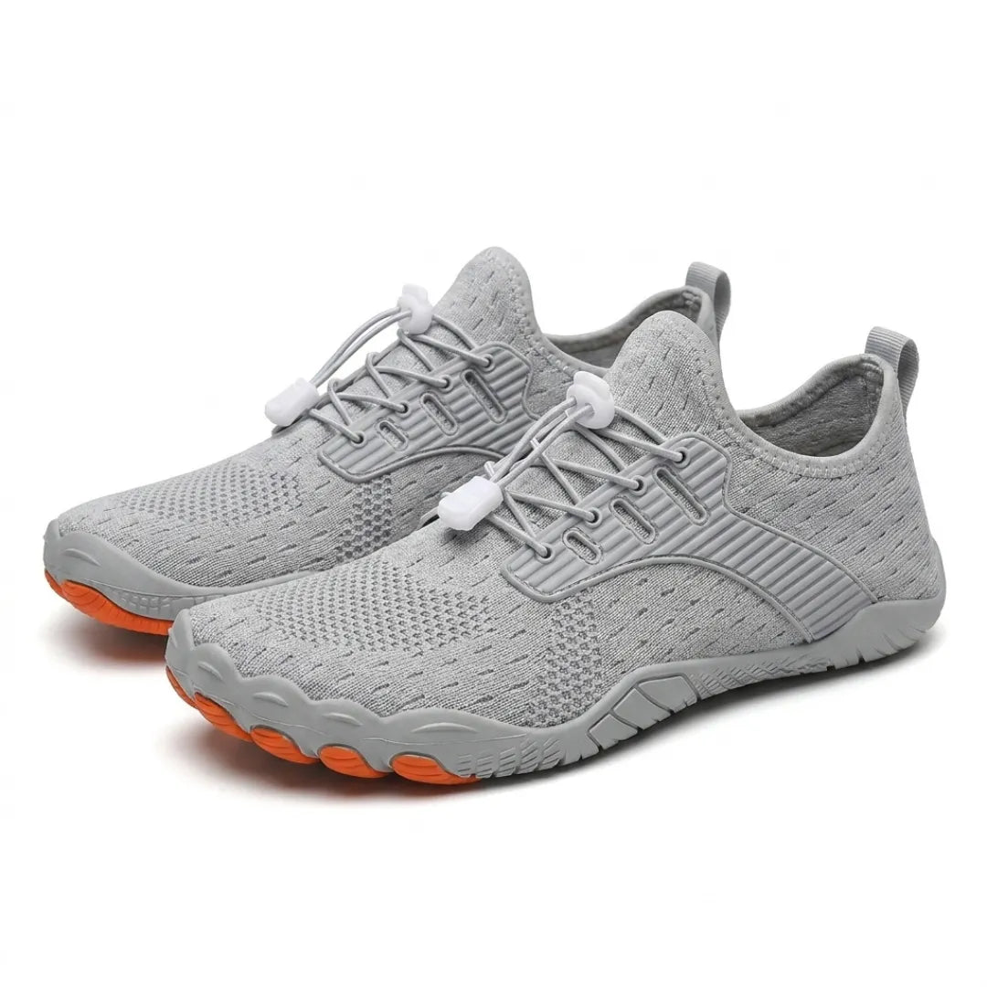 Pair of grey knit barefoot trainers at an angle, showing white toggle laces and grey sole with orange toe tips. 16