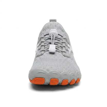 Front view of a grey trainer showing the broad rounded toe, white toggle laces and orange toe pads on the sole. 17