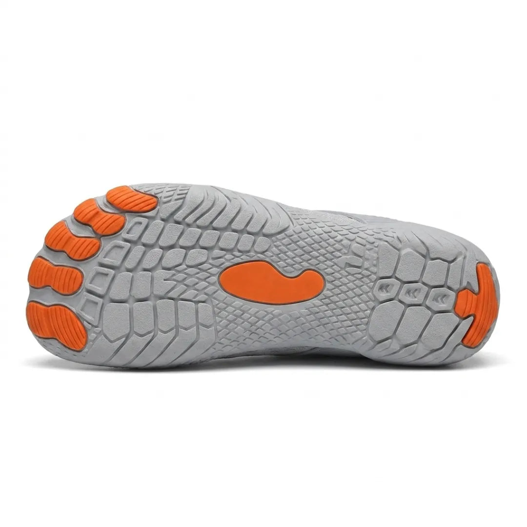 Underside of a grey trainer showing the textured grey tread with orange toe pads, centre patch and heel tip. 18