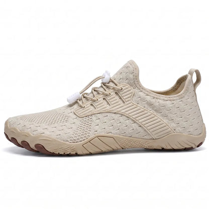 Side view of a beige knit barefoot trainer with white toggle laces, matching beige sole and brown toe tips. 19