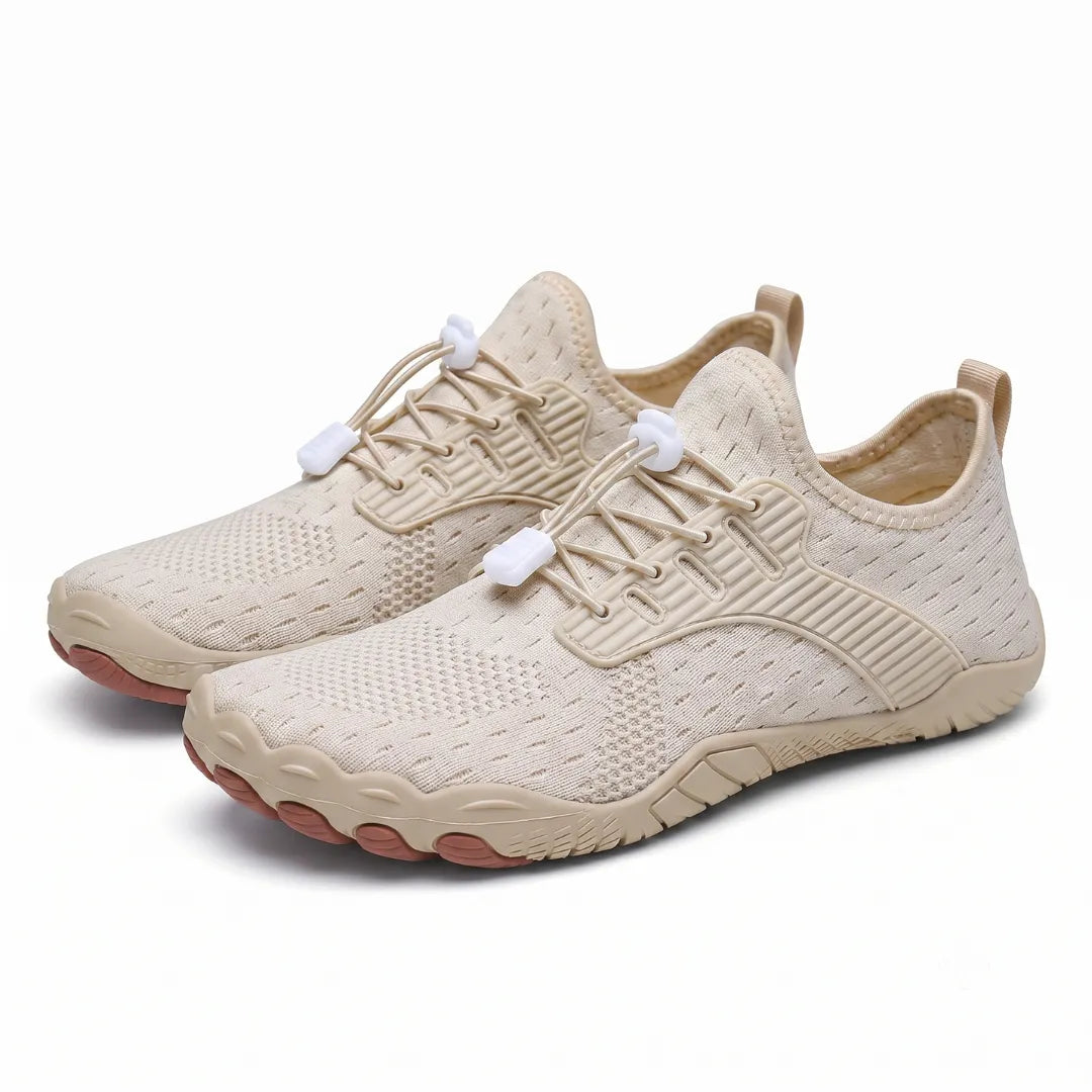 Pair of beige knit barefoot trainers seen from the front corner, with white toggle laces and a wide toe sole. 25