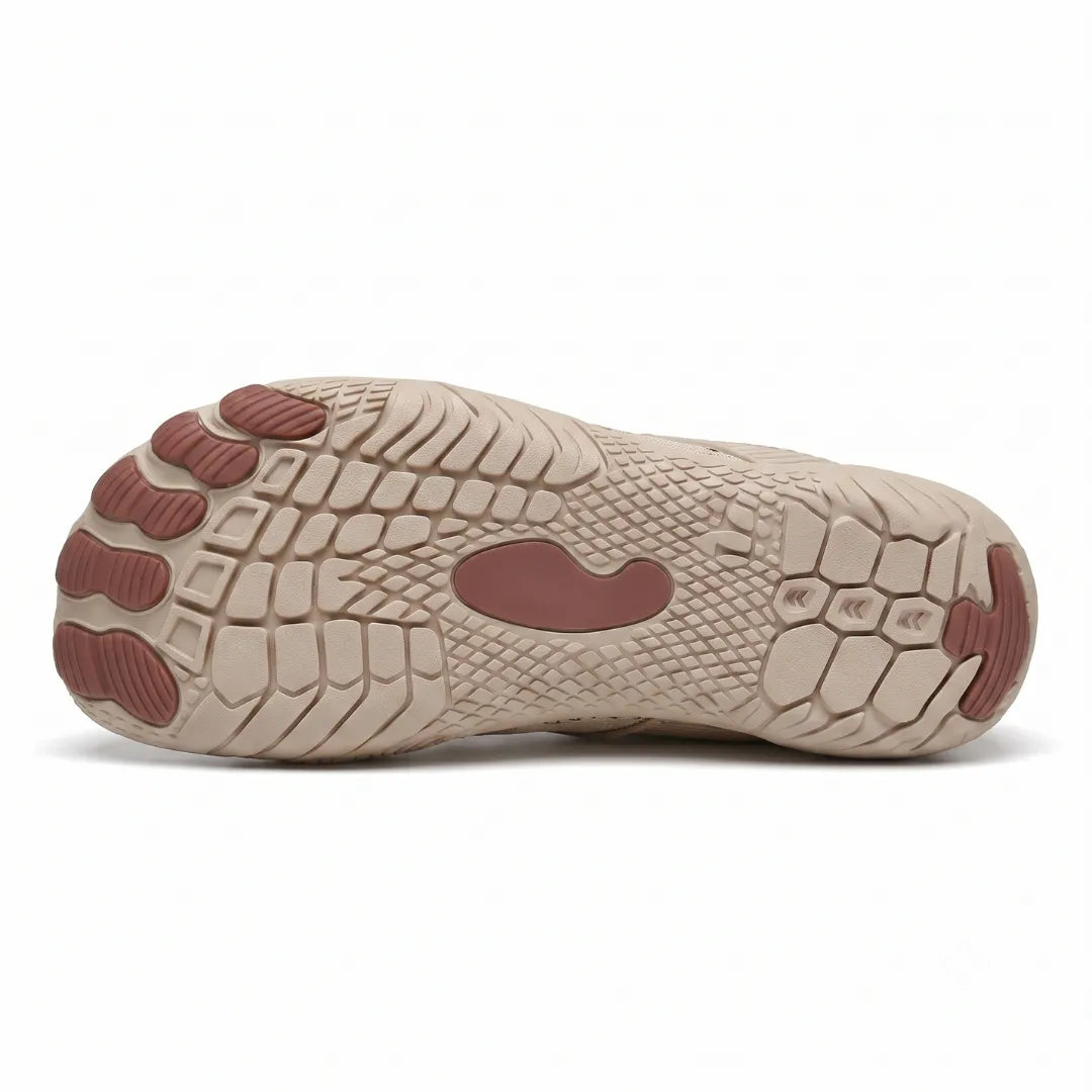 Underside of a beige trainer showing the textured tread, separate toe-shaped pads and a central brown grip patch. 27