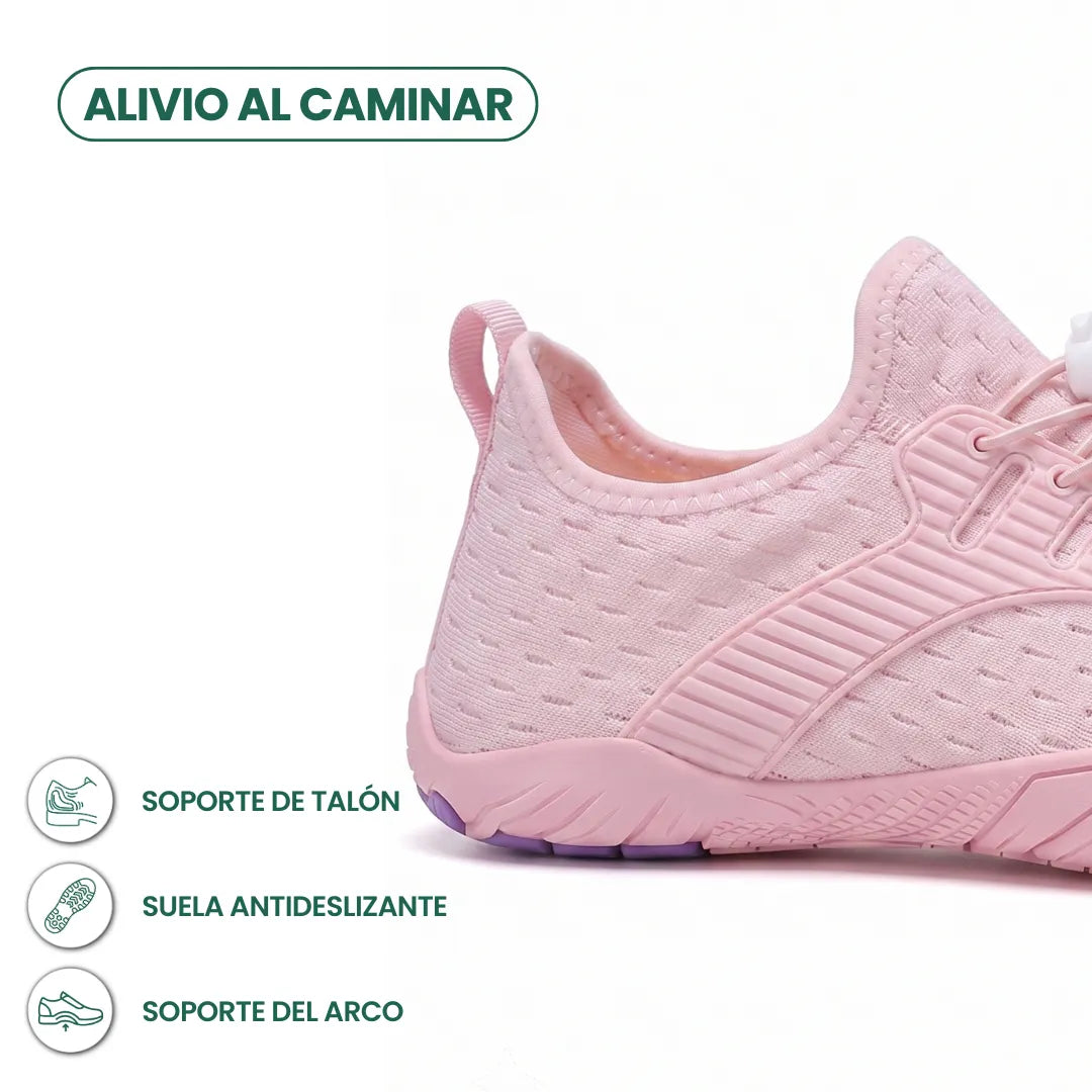 Heel and side close-up of a pink knit trainer showing the pull loop, ribbed overlay, grippy sole and graphic icons. 31