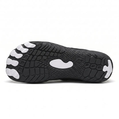 Underside of the black trainer showing the textured tread pattern with white toe pads, a white central patch and a white heel tip. 45