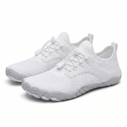 Pair of white knit barefoot trainers seen at an angle, showing elasticated laces and wide, rounded grey toe sole. 7