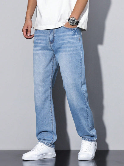 Light blue washed relaxed jeans on a model with a hand in the front pocket and white trainers. 8
