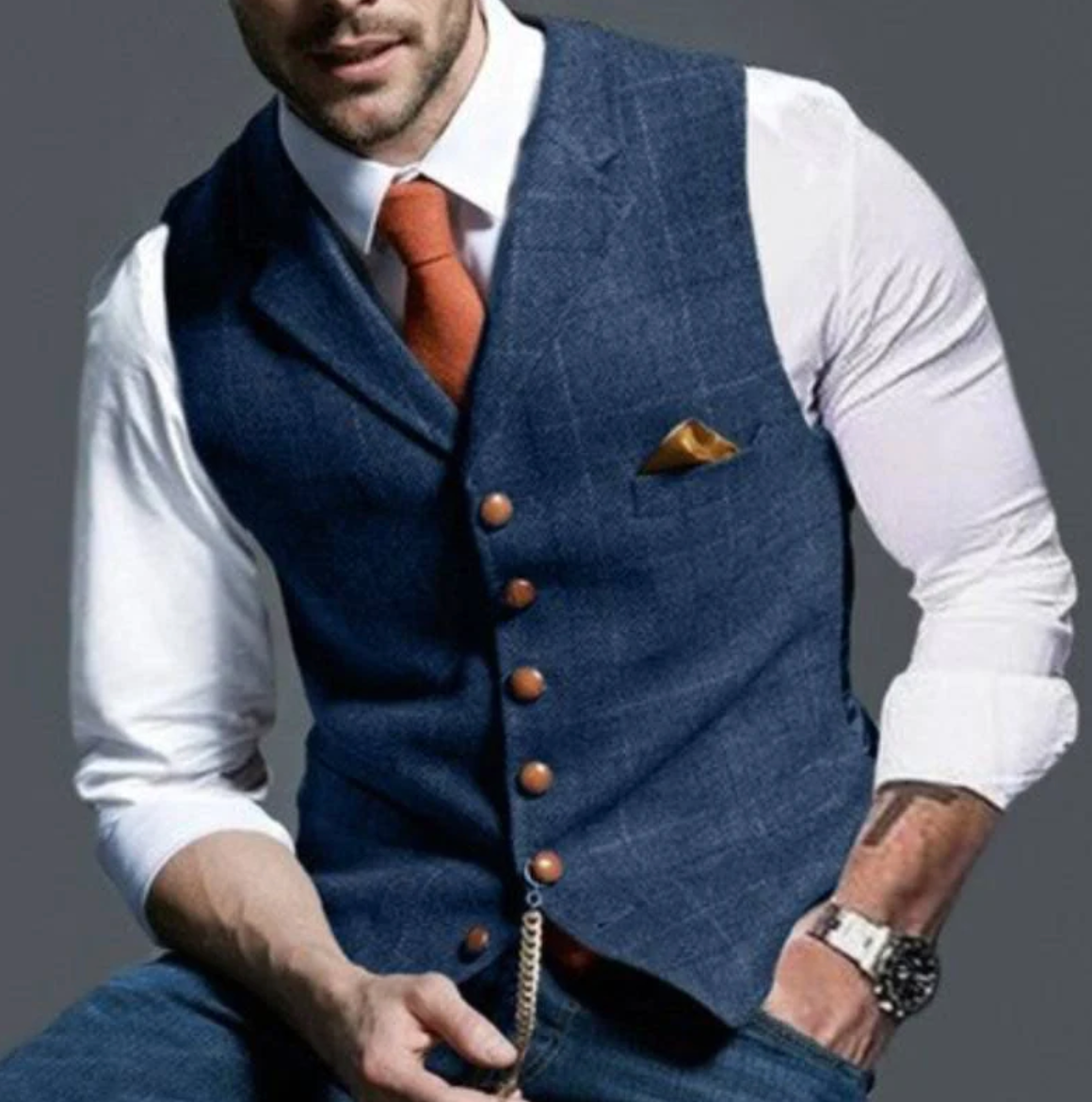Model wears the waistcoat in blue tweed over a white shirt with an orange tie 1