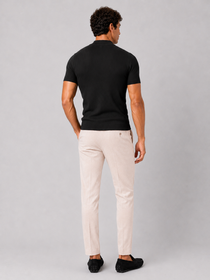 Back view of the black ribbed top worn with cream trousers and black loafers. 19