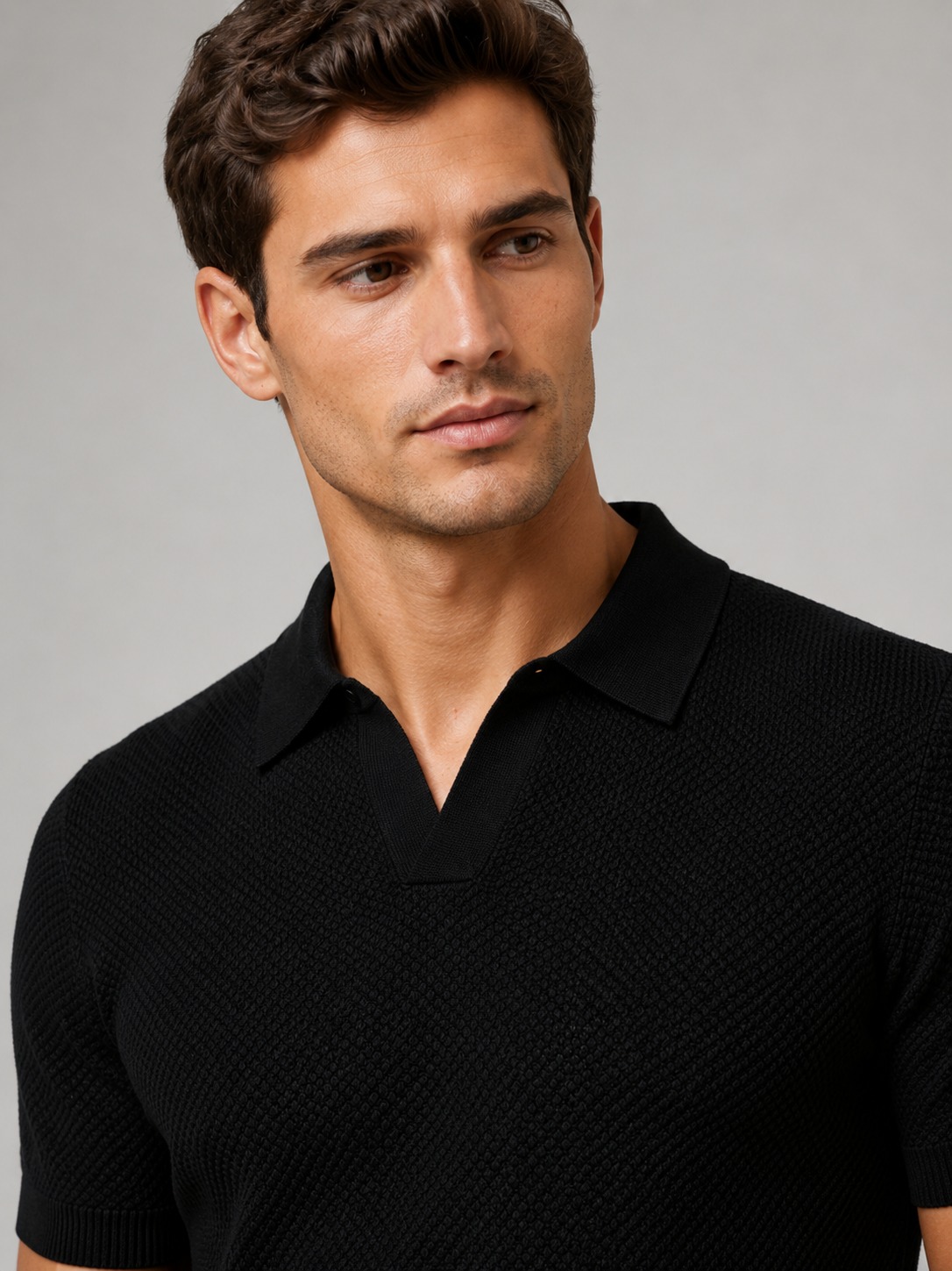 Close-up of black knit polo showing the open V collar and honeycomb texture 7