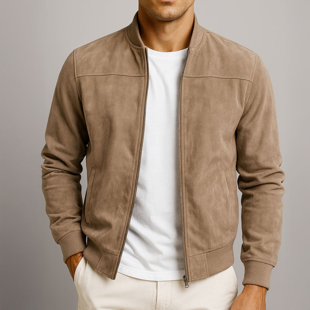 Front view of a man wearing the suede-look bomber in taupe, unzipped over a white T-shirt with cream trousers. 1