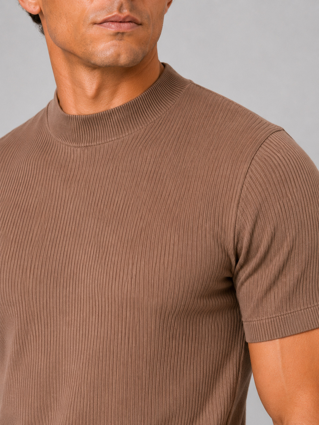 Close-up of the brown top's vertical ribbed knit, mock neck collar, shoulder seam and short sleeve cuff. 2