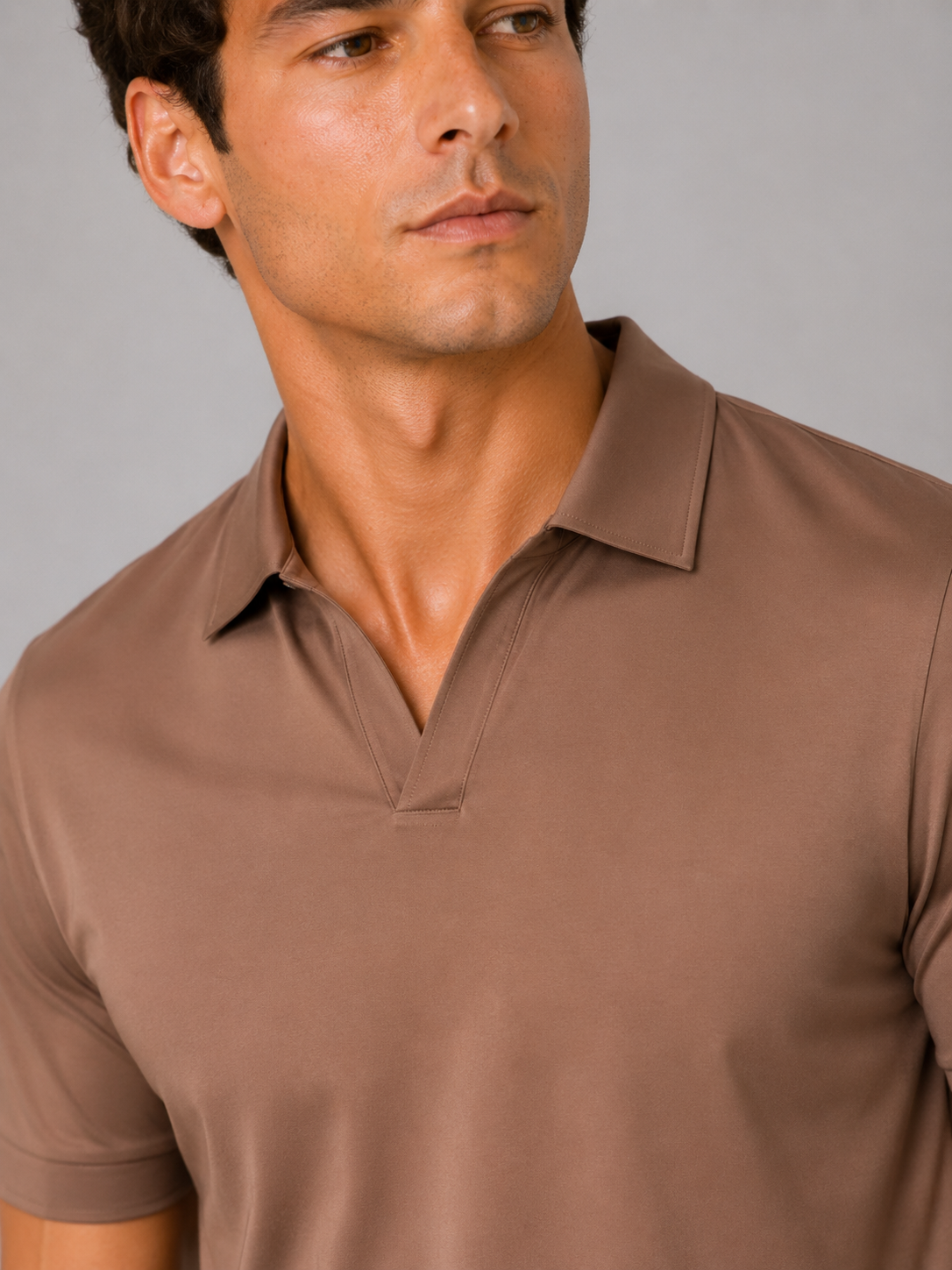 Close-up of the brown polo's V-neckline and collar, showing the fine stitching and smooth, slightly sheeny fabric. 12