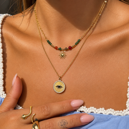 Model wearing the beaded sun necklace layered with a longer gold chain and round eye pendant 3