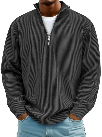 Man wearing the ribbed half-zip jumper in charcoal black over a white tee, hands in jeans pockets, front view. 4