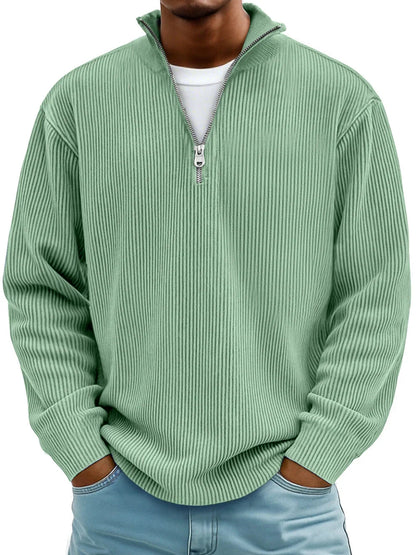 Man wearing the ribbed half-zip jumper in mint green over a white tee, hands in jeans pockets, front view. 8