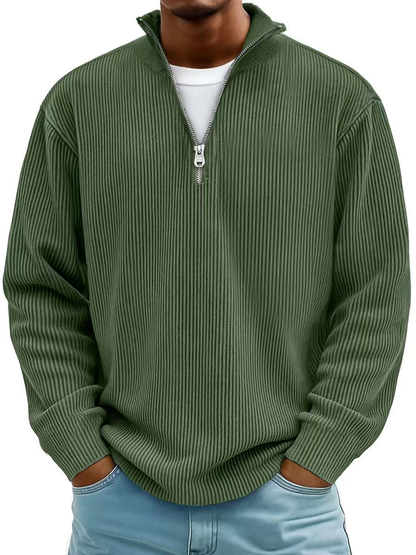Man wearing the ribbed half-zip jumper in olive green over a white tee, hands in jeans pockets, front view. 10