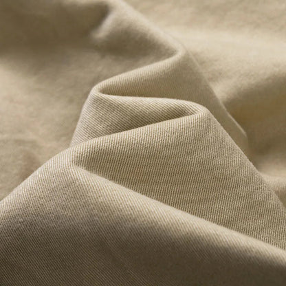 Close-up of soft folds of khaki twill fabric showing the fine diagonal weave. 8