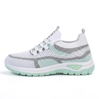 Side view of the white mesh trainer in a mint green colourway with grey overlays and a mint sole. 10