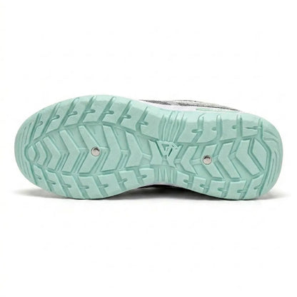 Underside of the mint green sole, showing a deep chevron tread pattern with two small metal studs. 18