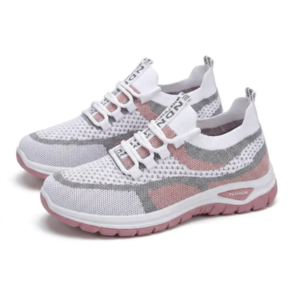 Pair of white, grey and pink knit mesh trainers with pink soles, shown at an angle on a plain white background. 25