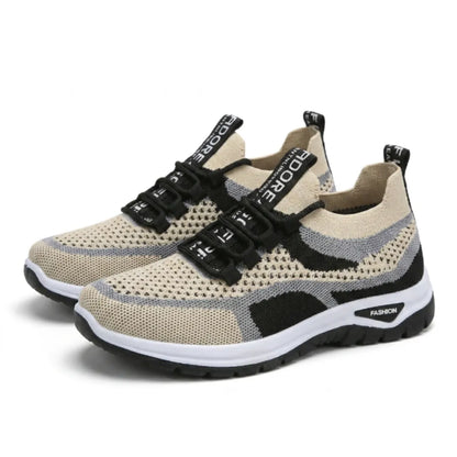 Pair of beige trainers with grey and black accents, perforated mesh uppers, black laces with lettered tabs and a white and black sole, angled view. 43
