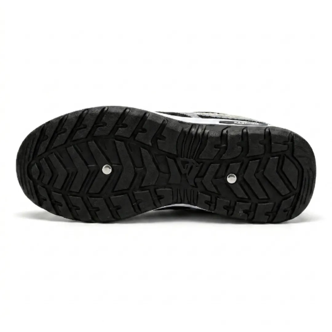 Underside of the trainer showing the black rubber outsole with a deep chevron grip pattern, two small metal studs and a white edge. 45