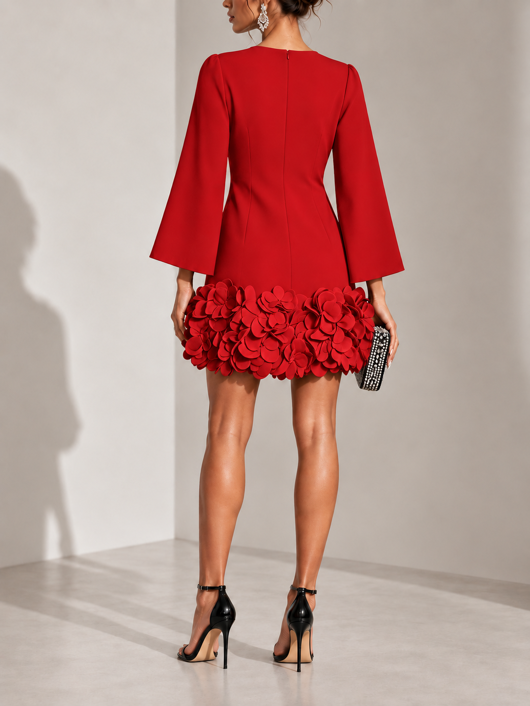 Back view of the red dress showing the centre zip, flared sleeves and clustered petal hem. 15