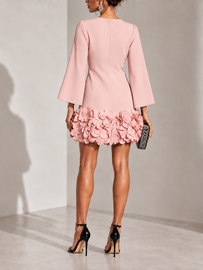 Back view of the dusty pink dress with centre zip, flared sleeves and a ruffled petal hem, worn with black heels. 10