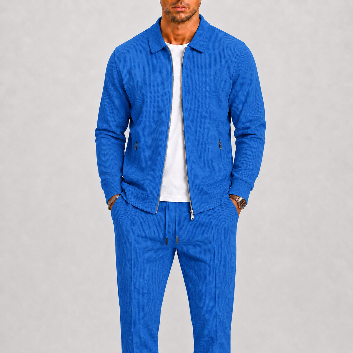 Model wearing the bright blue waffle-textured zip jacket and matching trousers over a white t-shirt 5