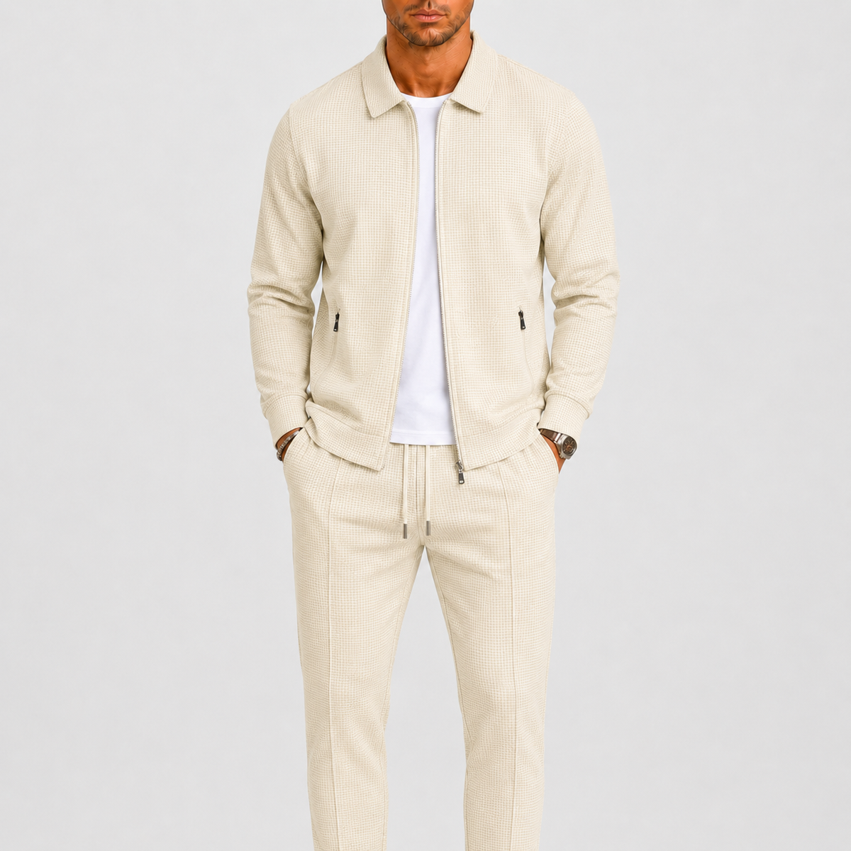 Model wearing the cream waffle-textured zip jacket and drawstring trousers over a white t-shirt 1