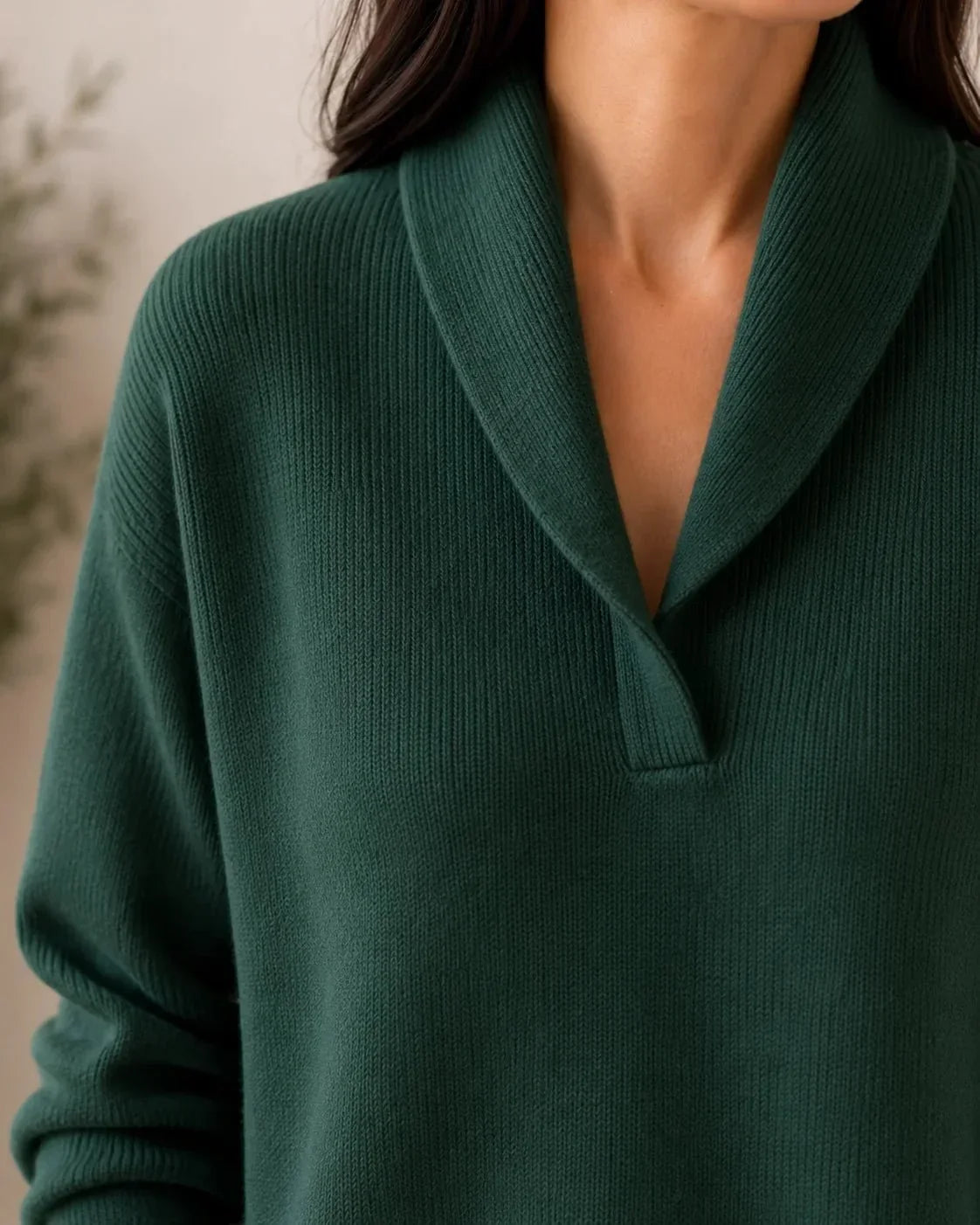 Close-up of the dark green jumper's shawl collar and V-neckline, showing the fine ribbed knit texture. 5