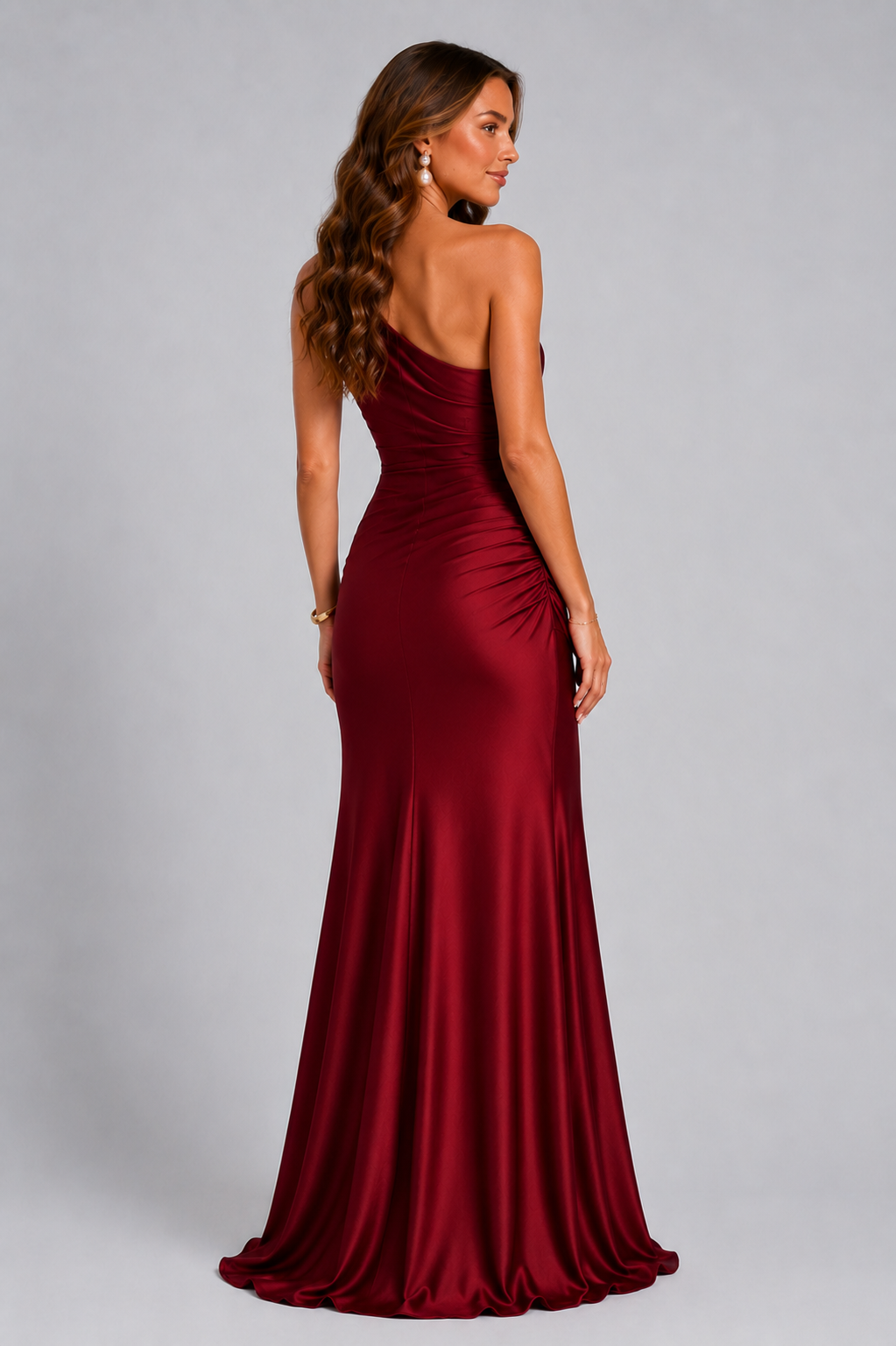 Back view of the deep red dress, with a bare back on one side, a centre seam and ruching at the hip. 10