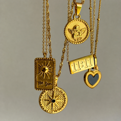 Star pendant hanging beside other gold pendants, including a sun tag, a cherub coin and a heart charm 4