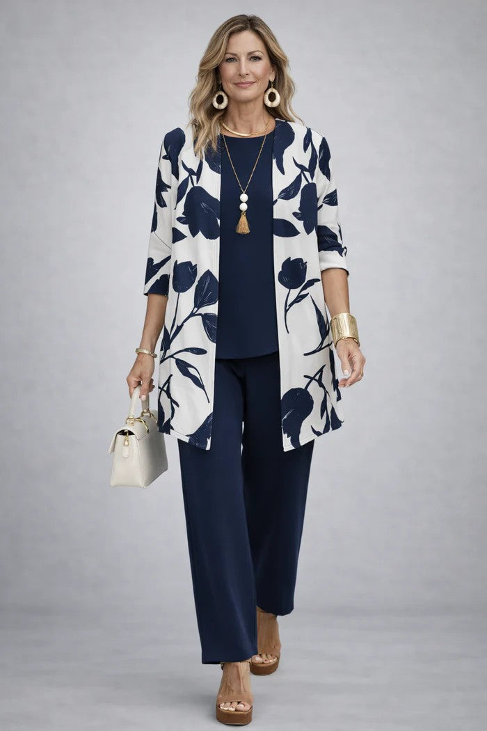 Woman in a white cardigan with navy tulip print over a plain navy top and trousers 8