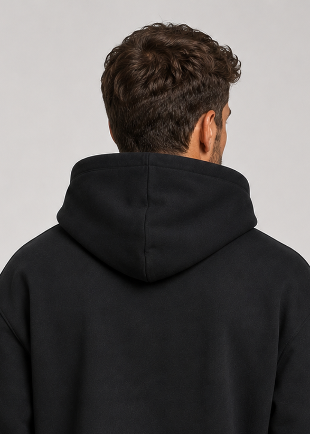 Close view from behind of the black hoodie's hood and upper back, showing the seam running down the centre of the hood. 4
