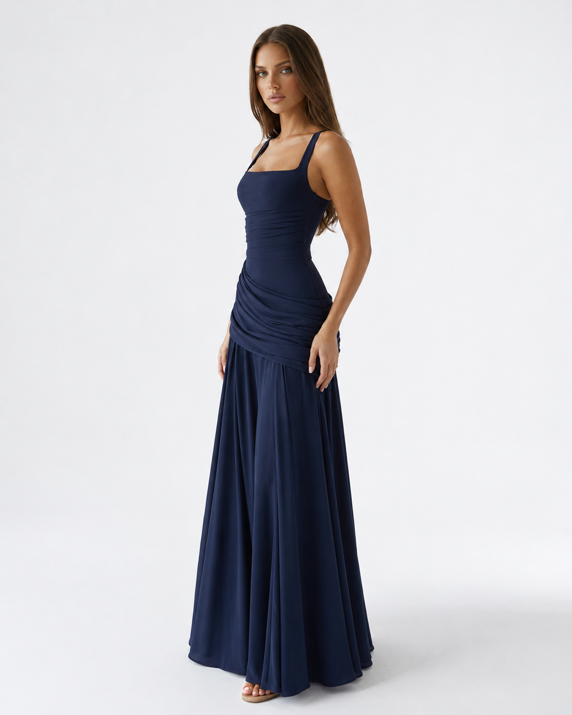 Navy blue maxi dress on a model from the front three-quarter angle, with square neckline and draped gathered waist. 6