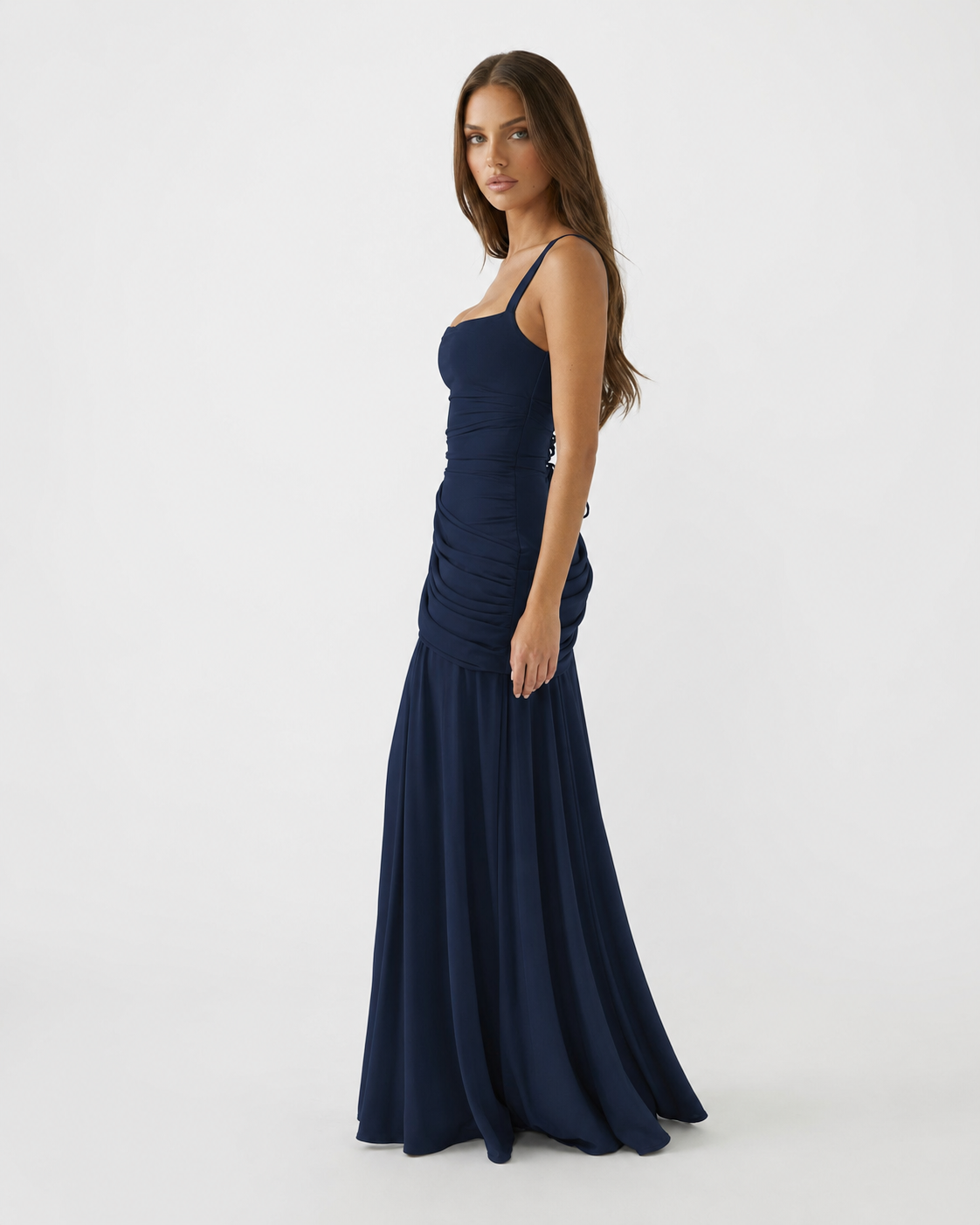 Side view of the navy blue maxi dress, showing ruching at the hip and the long flared skirt. 7
