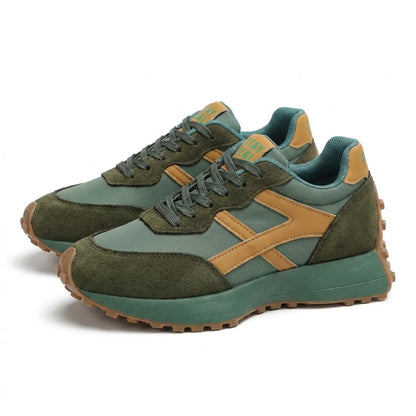 Pair of green trainers with tan stripes and gum soles, shown at an angle 13