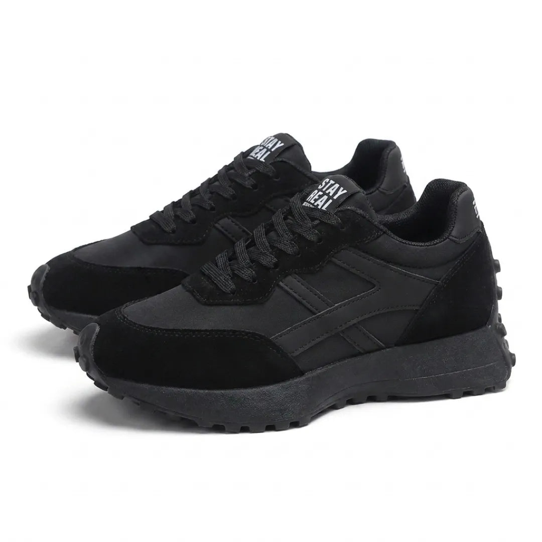 Pair of all-black lace-up trainers shown at an angle on a white background 8