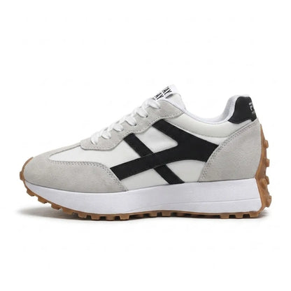 Side view of a single lace-up platform trainer with grey suede panels, black stripe and gum-coloured studded sole 21