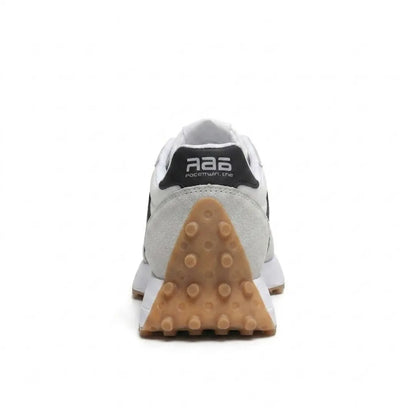 Rear view of a trainer showing the black heel tab and triangular studded gum-coloured heel 25
