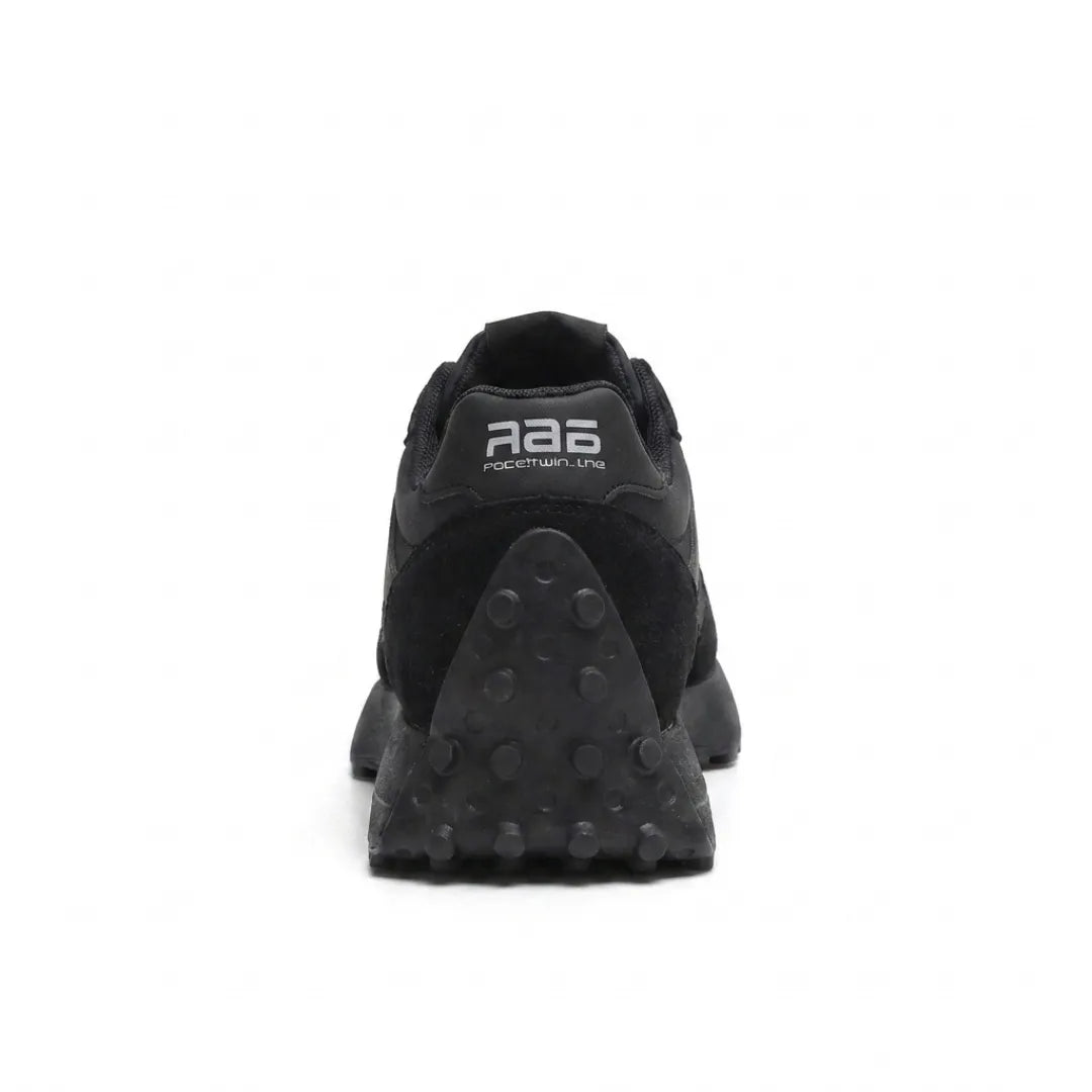 Rear view of the all-black trainer showing heel tab and studded heel sole 10