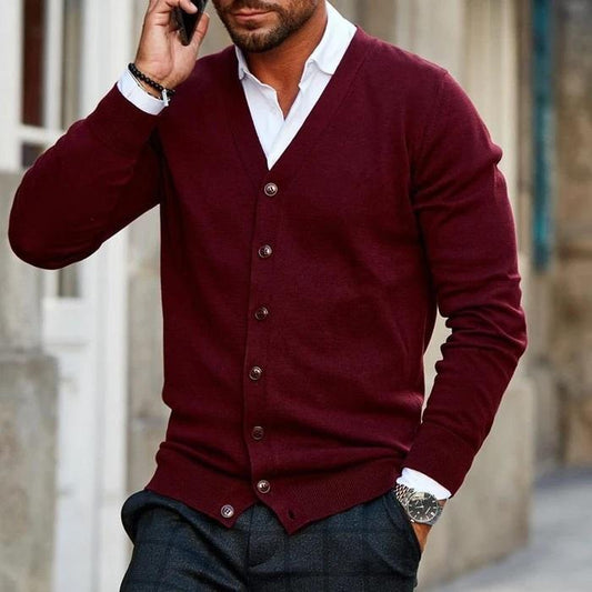 Man in a burgundy buttoned cardigan over a white shirt, holding a phone to his ear 1