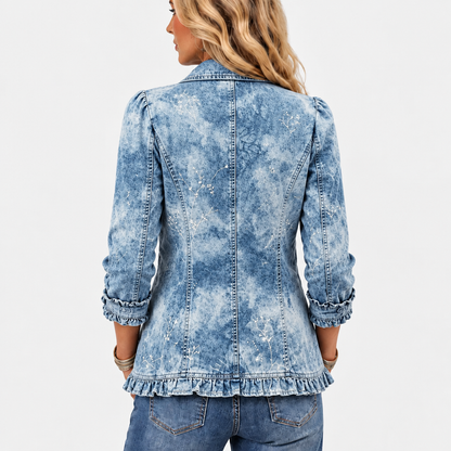 Back view of the washed denim jacket showing seamed panels, delicate white botanical print and a ruffled hem 4